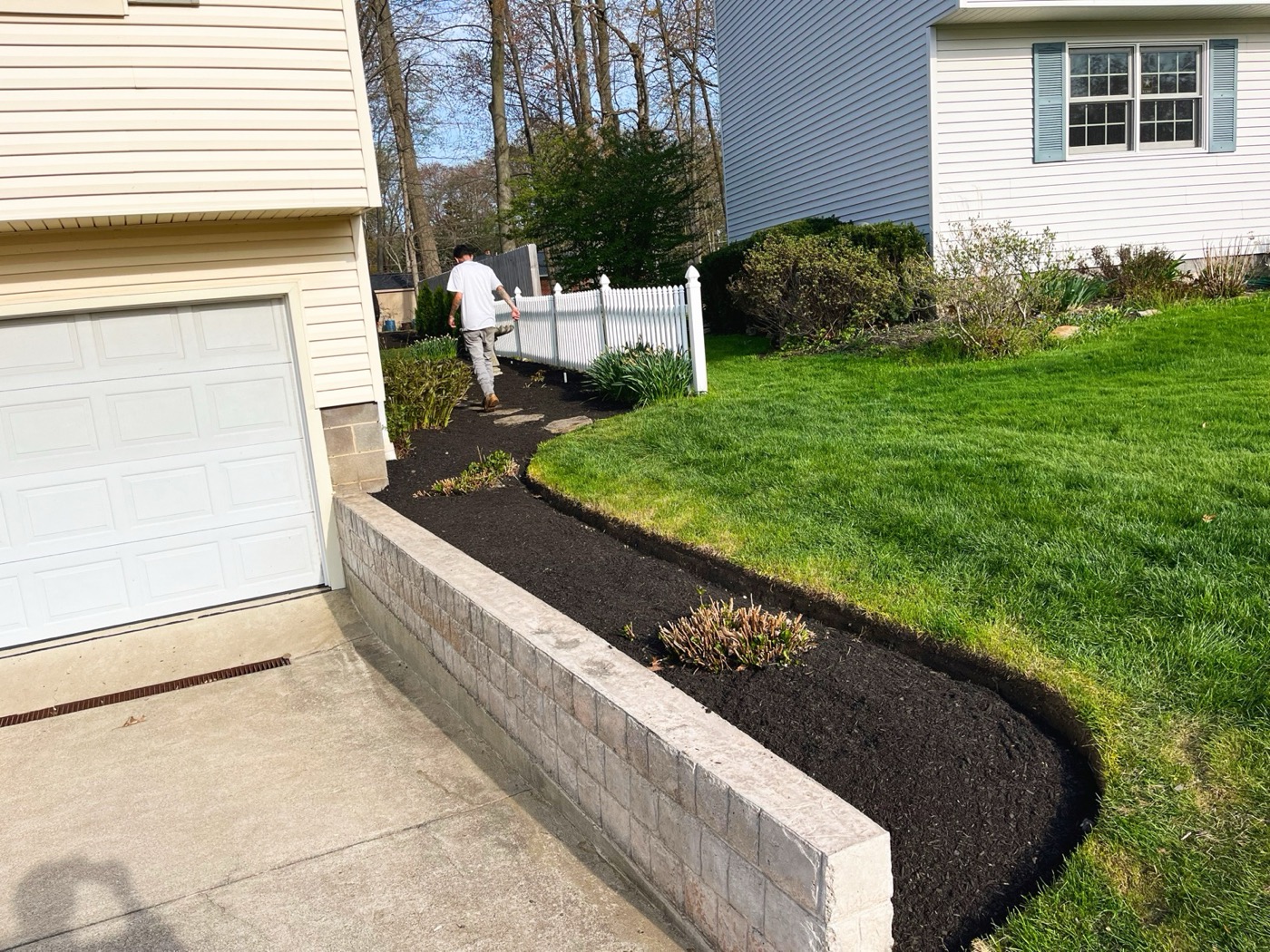 Same driveway with a new stone retaining wall and fresh dark mulch bed